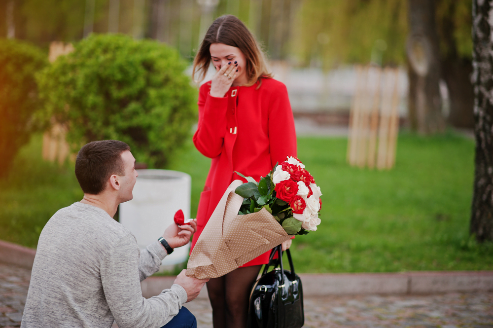 Marriage proposal Man with boquet of flowers kneeling and give engagement ring for his girlfriend
