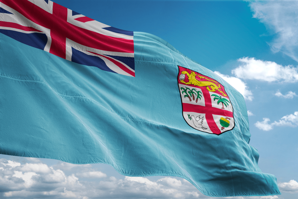 Fiji national flag closeup waving blue sky
