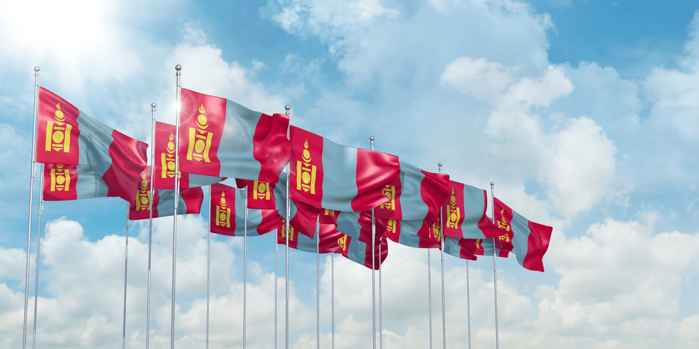 3d illustration of many flags of Mongolia in rows waving in the wind against blue sky