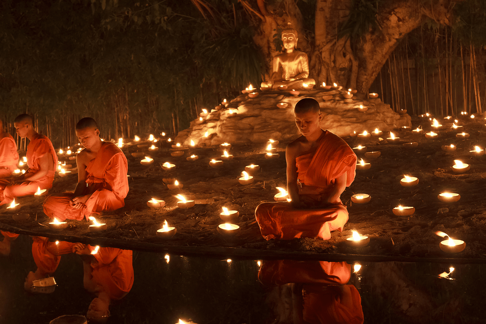 Makha Bucha Day.Traditional buddhist monks are lighting candles for religious ceremonies