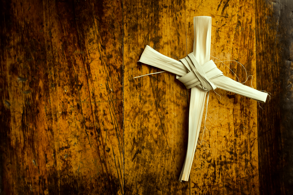 This Palm Branch was folded into a Cross shape and photographed on an antique wooden seat It represents the Easter Season including Palm Sunday and Good Friday Palm Branch Cross is my creation