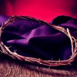 closeup of the the crown of thorns of Jesus Christ on a purple fabric